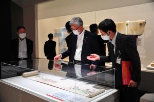 写真：職員から展示物の説明を受ける市長