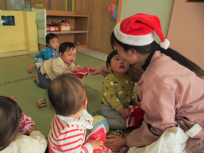 0歳児がクリスマスプレゼントをもらっている写真