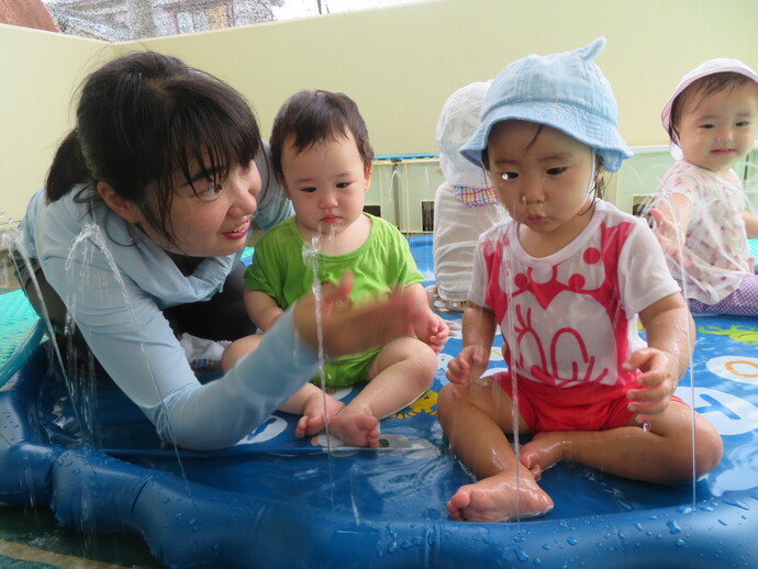水遊びをする子どもと保育者