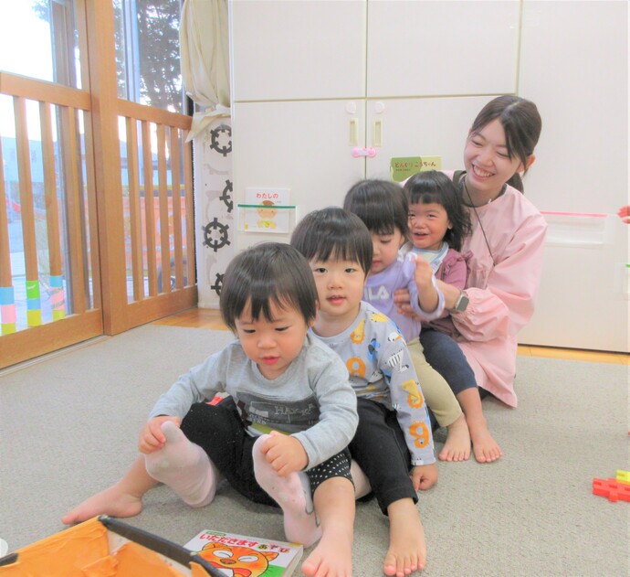 写真:ふれあい遊びをしている保育者と子どもたち