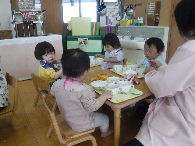 写真:先生と給食を食べる1歳児