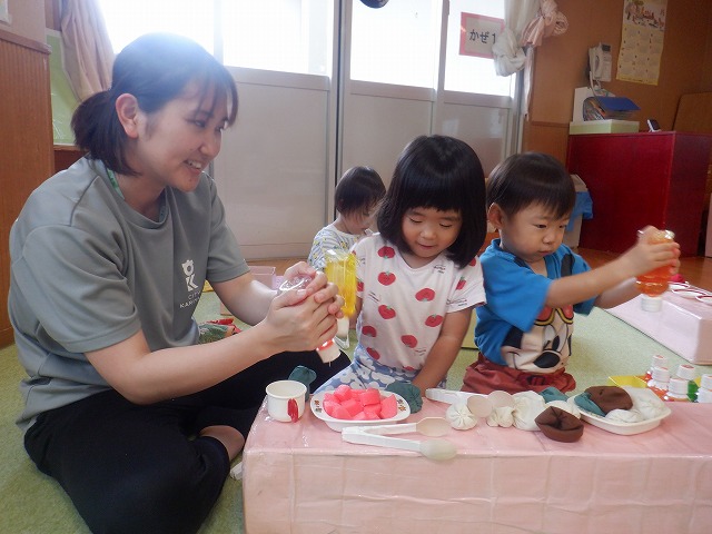 写真:保育者とままごとをしている様子