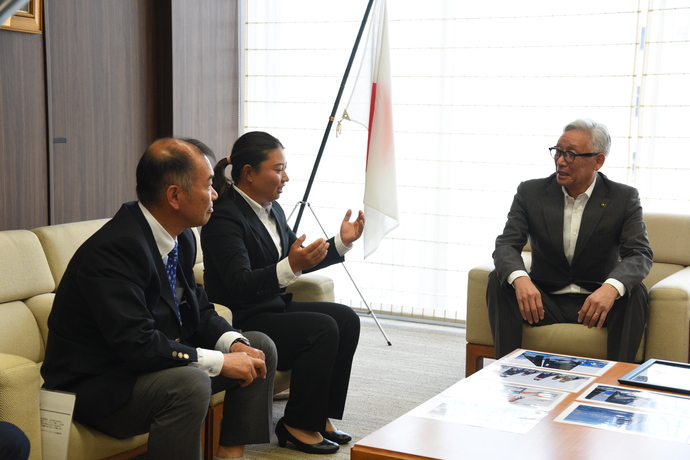 写真を見ながら会話をする田中選手と市長